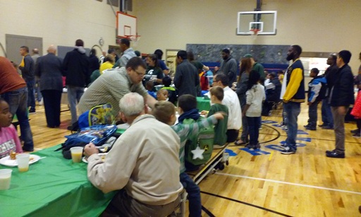 Family, staff and students are gathered in the gym to eat their tasty breakfast.