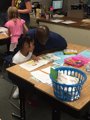 A father reads a book with his daughter.