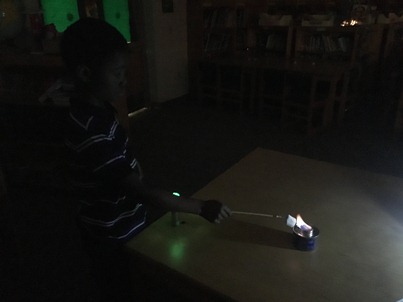 A boy carefully roasts a marshmallow.