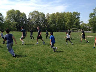 The students and the varsity soccer players, on the field and ready to play!